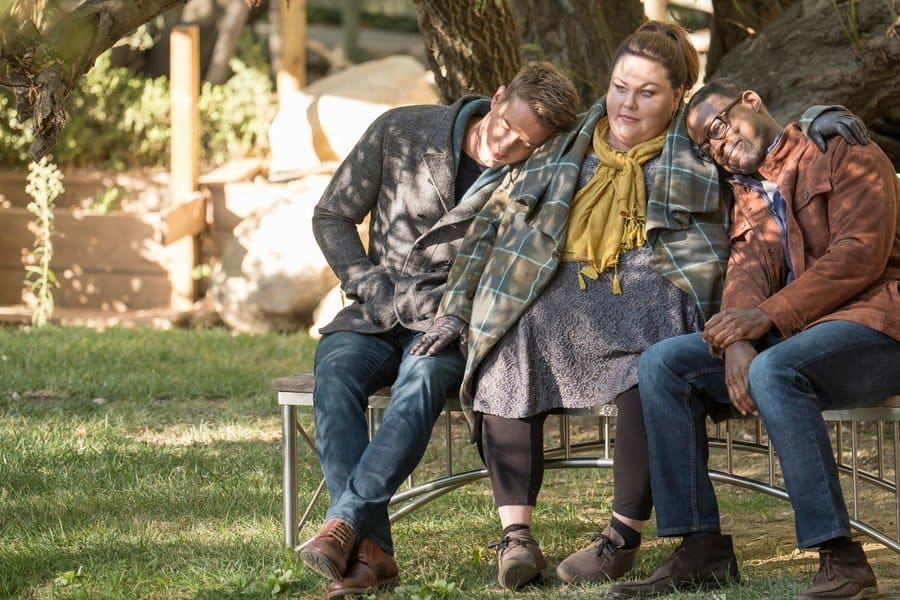 Kevin, Kate, and Randall sitting on a bench in the lawn at the rehab center in the show.