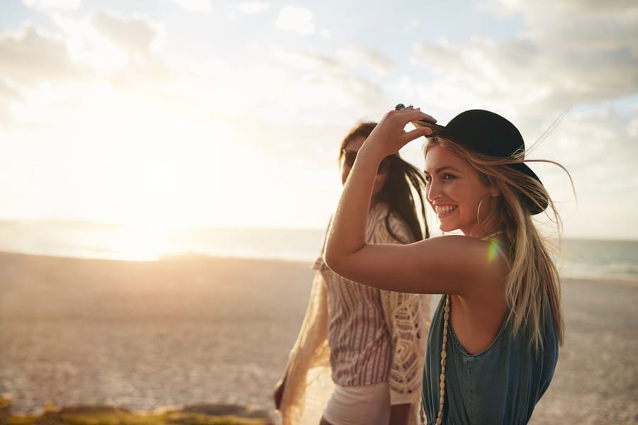 Stock photo of two young women walking together on the beach.