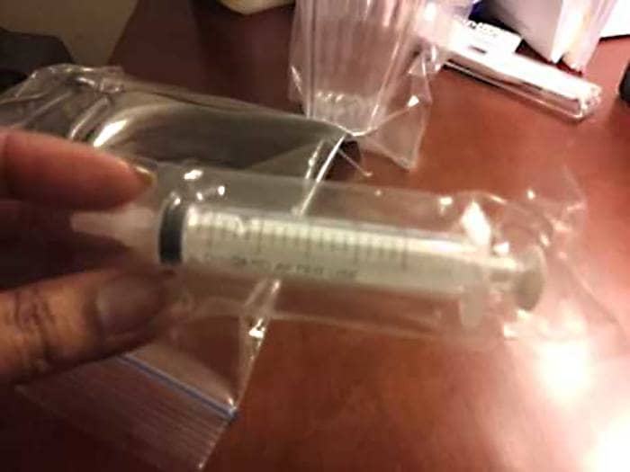Woman’s hand holding an injector.