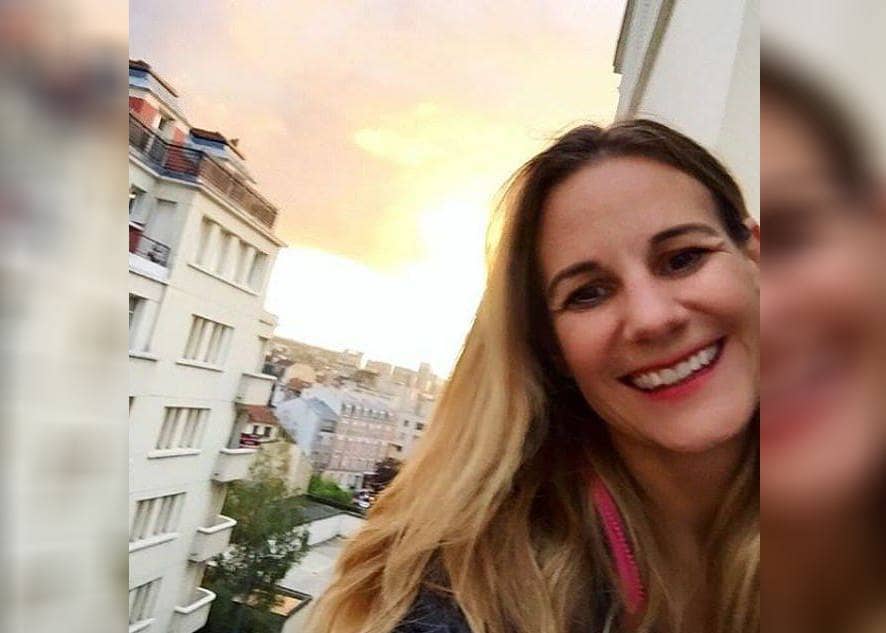 Photo of Jessica smiling with a sunset view behind her.