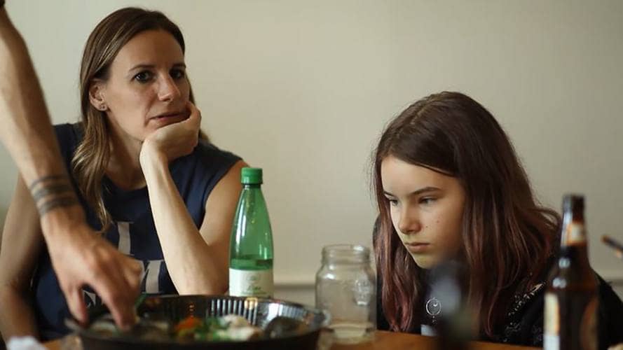 Jessica with her daughter Alice sitting near a dining table.