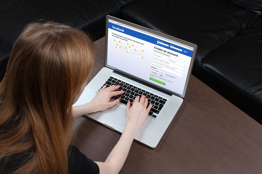 Stock photo of a woman searching on Facebook on her laptop.