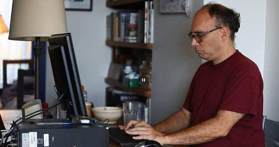 Photo of Aaron typing on a computer.