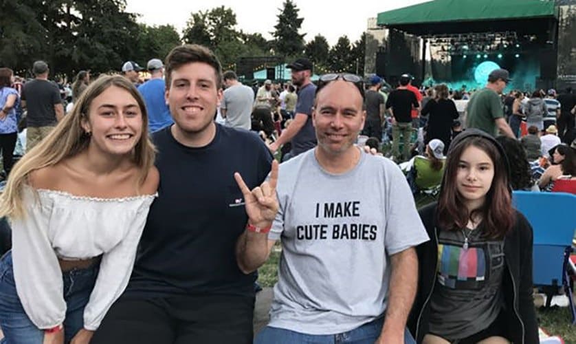 Aaron with his children photographed at a concert outside.