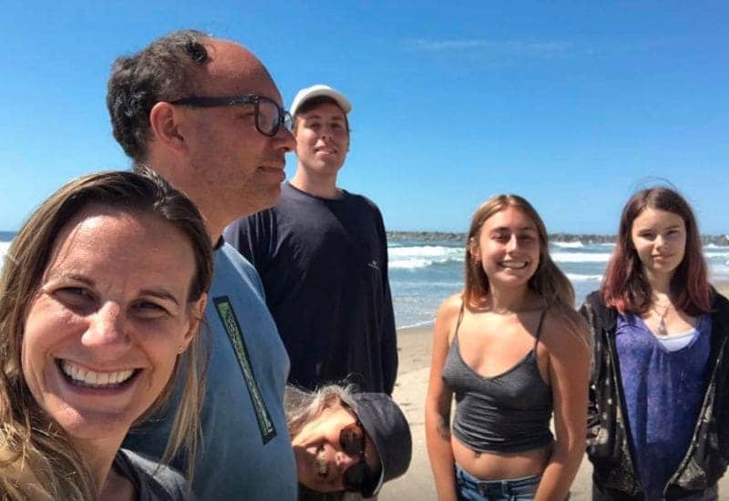 Jessica, Alice, Maddie, Bruce, and Aaron photographed together in a selfie on the beach.