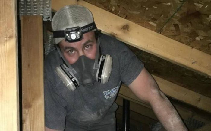 A man with a mask on doing some construction work