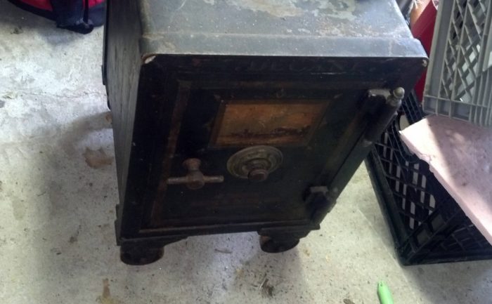 An old rusty safe sitting on the ground