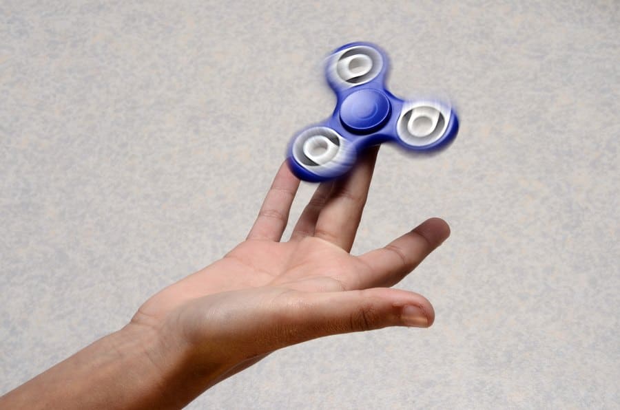 Blue Hand spinner rotating on the child's hand.