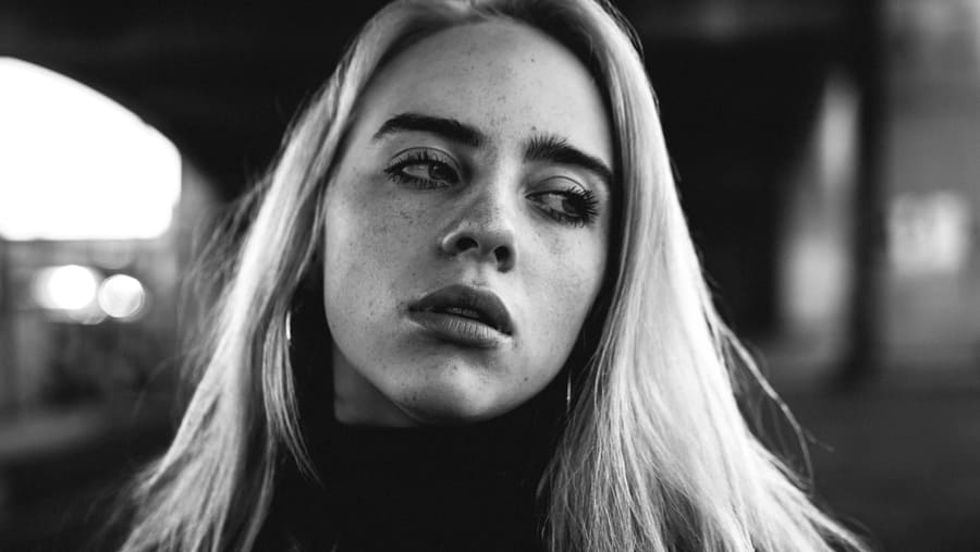 A black and white photograph of Billie Eilish. 