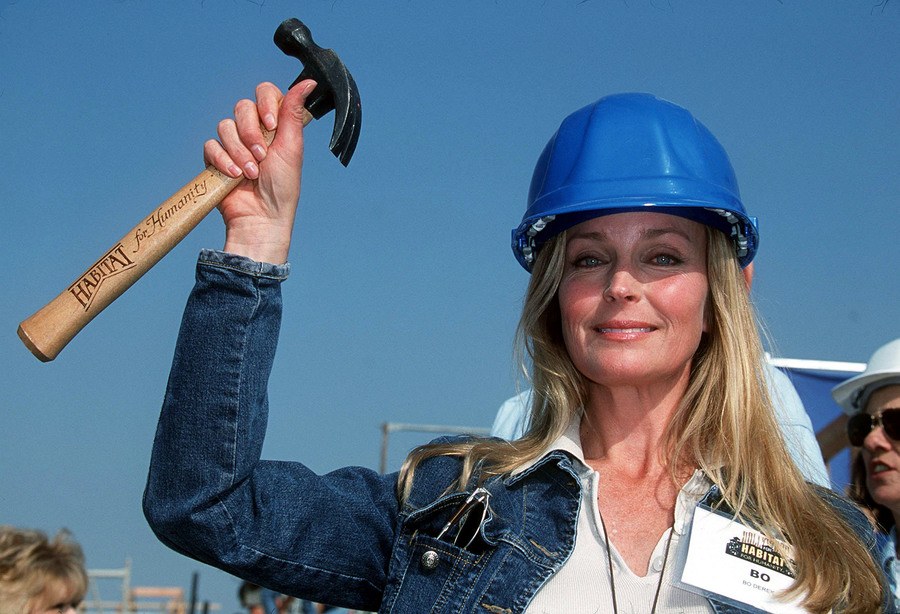 Bo Derek is holding a hammer while building houses with Hollywood for Habitat.