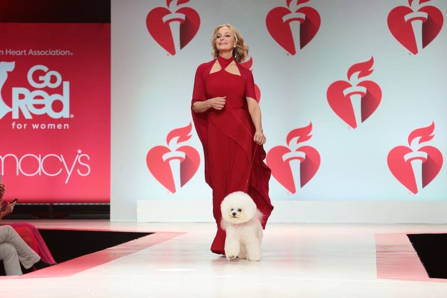 Bo Derek and a fluffy white dog named Flynn walking down the runway dressed in red at the ‘Go Red For Women’ event in 2019. 