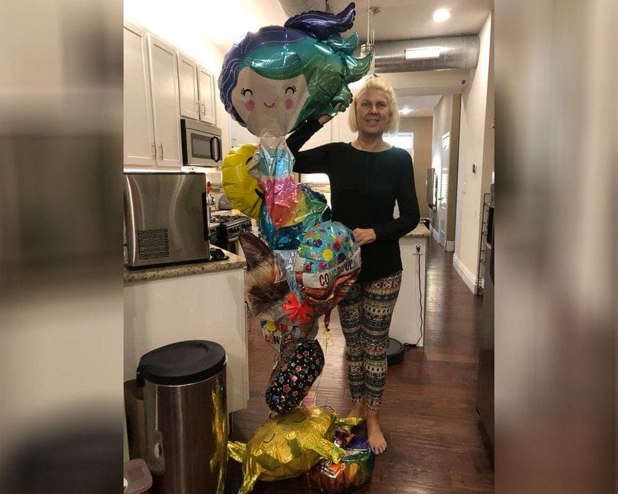 Kasey Bergh at home holding balloons