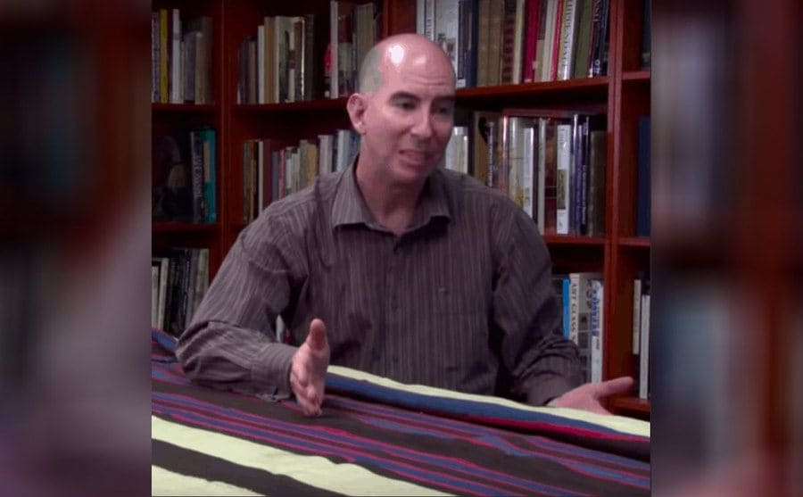 Jeff talking to the camera with the blanket on the table