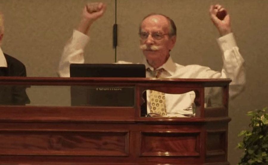 An auctioneer with his hands up