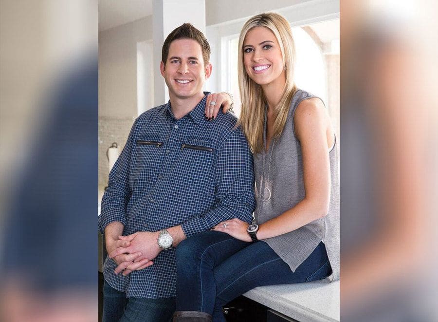 Tarek and Christina El Moussa posing on a kitchen countertop in 2014.