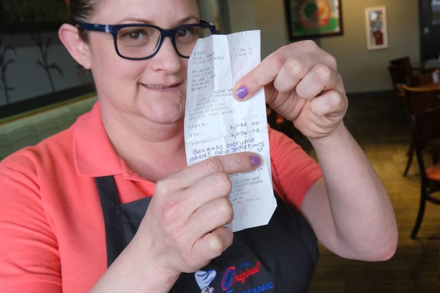 Shannon Vargas holding her receipt with a $2020 tip