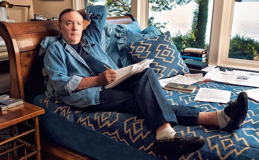 James Patterson sitting in a bed with his notes in front of him 