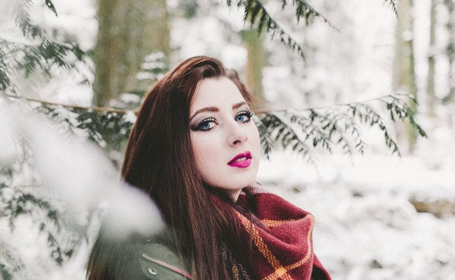 Laura photographed with blurry snow-covered woods behind her