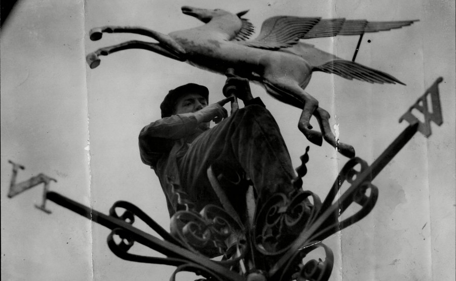 A man fixing the Pegasus Weathervane in London in 1922.