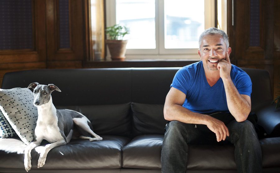 Cesar Millan and a dog on his leather couch 