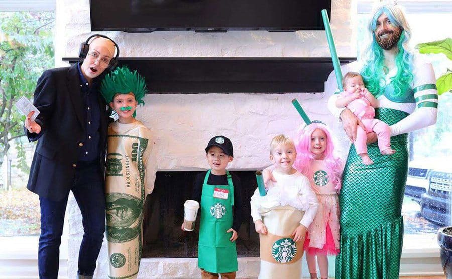 Myka and James with their five children, including Huxley, dressed like Starbucks drinks, a customer, some money, the mermaid on their cup, and a barista for Halloween 