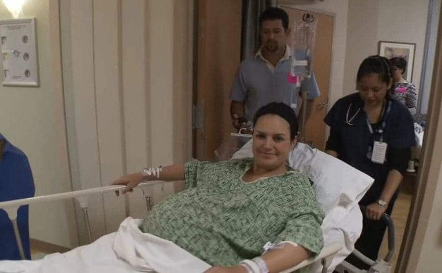 Angie being wheeled out of the hospital room in the bed