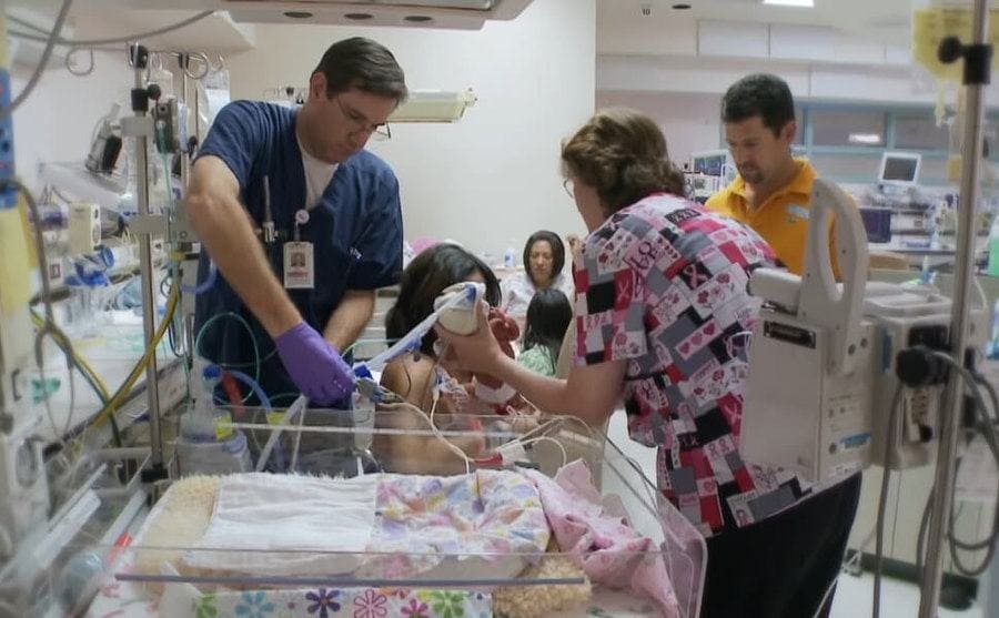 Angie being handed her baby in the NICU 
