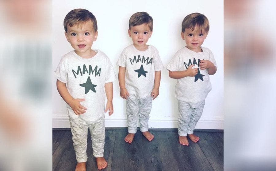 The triplets in matching white tops which say ‘Mama’ and camouflage bottoms 