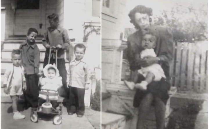 An old photograph of a family with children in front of a house and a mother holding a baby 