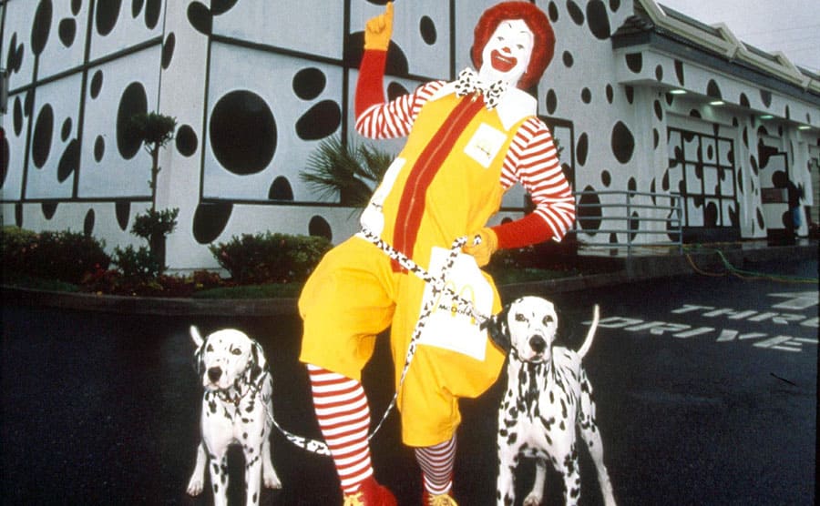 Ronald McDonald in front of a McDonald’s Play Place with two dalmatian dogs 