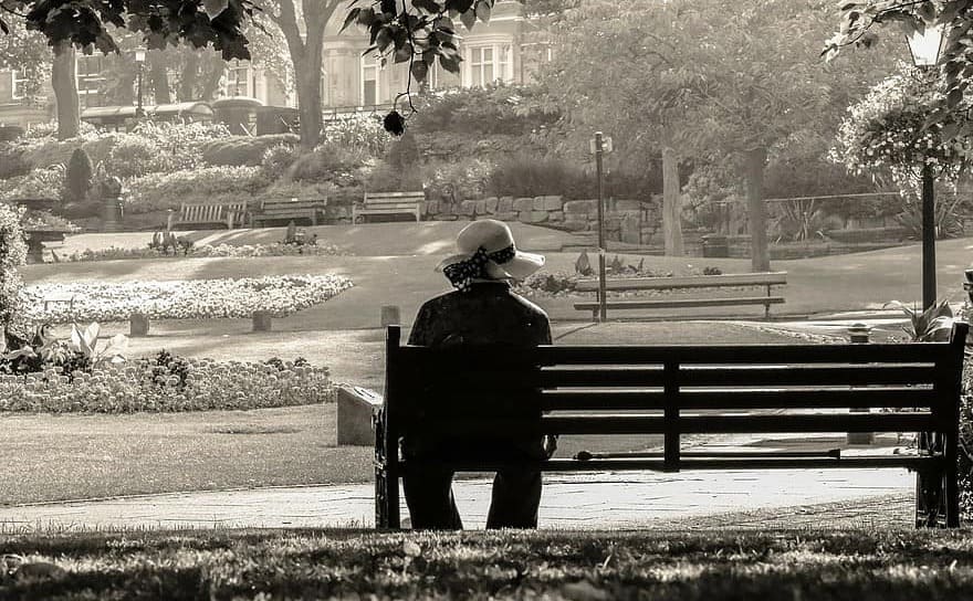 A woman sitting alone on a park bench 