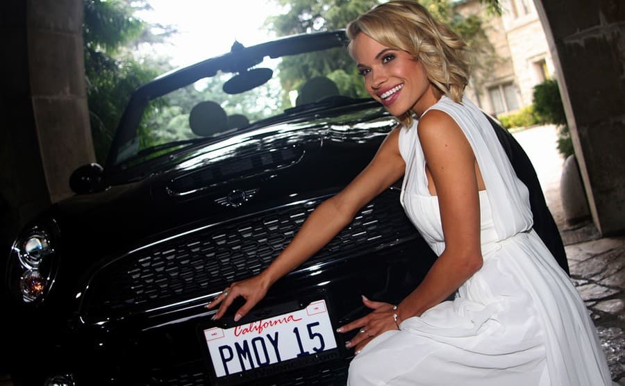 Dani Mathers posing with a new 2015 Mini Cooper S Convertible in midnight black 