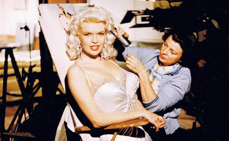 Jayne Mansfield getting her hair curled on the set of a movie 