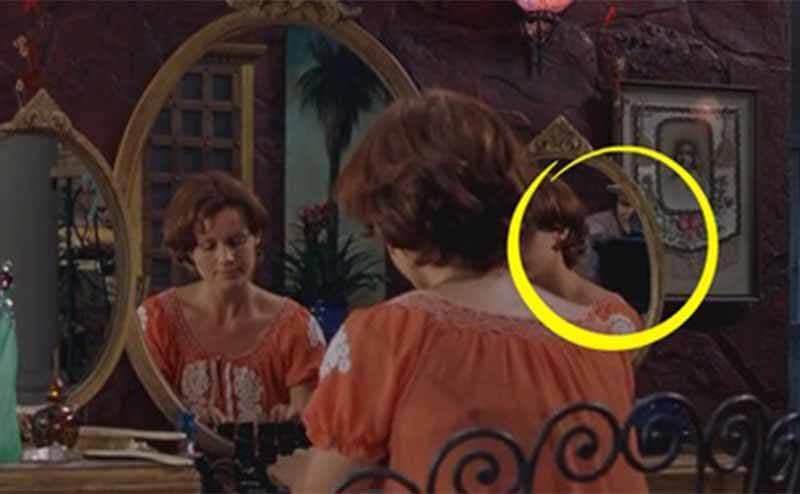 Someone sitting at a makeup table in the film Spy Kids with the cameraman visible from the tri-fold mirror