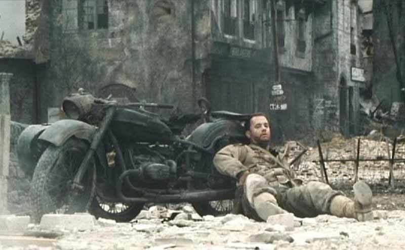 Tom Hanks leaning on a motorcycle in the film Saving Private Ryan 