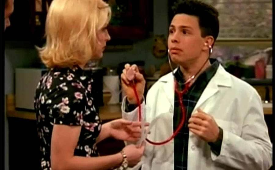 Jason Marsden holding a stethoscope with a woman in front of him in an episode of Step by Step 