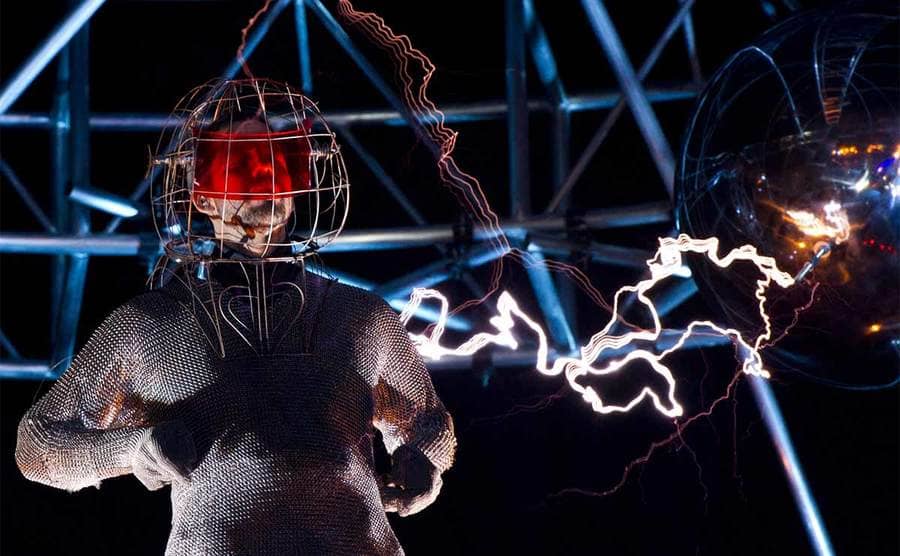 David Blaine in a full metal suit with electricity beams visible around him 