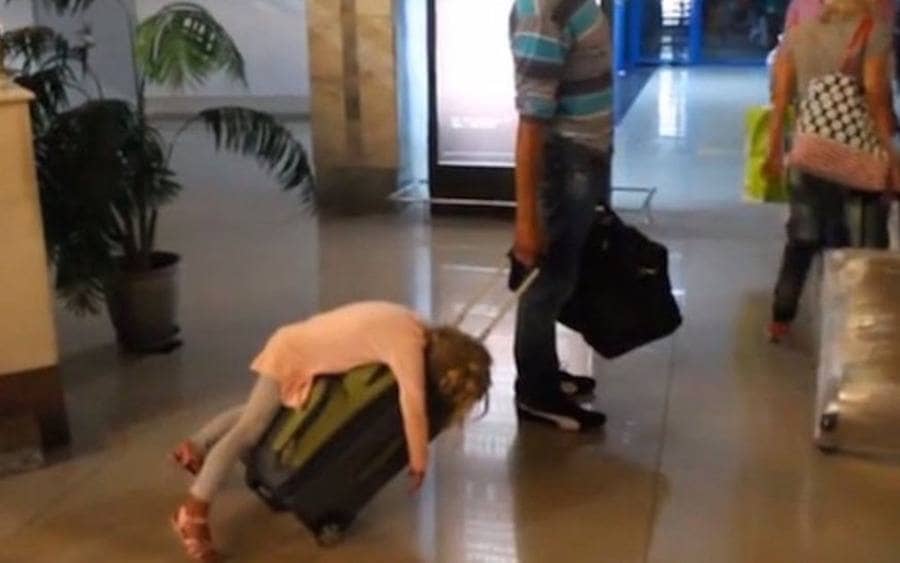 A kid is sleeping on a suitcase