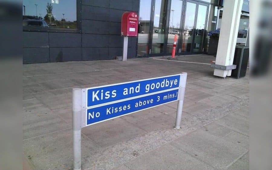 Kiss and goodbye sign near an entrance to an airport