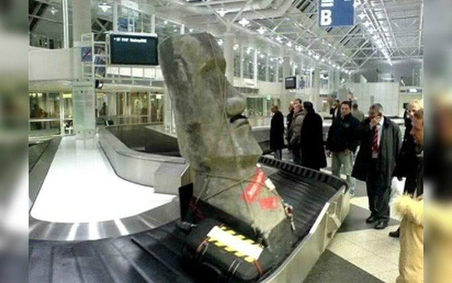 A statue from Easter Island on an airport carousel