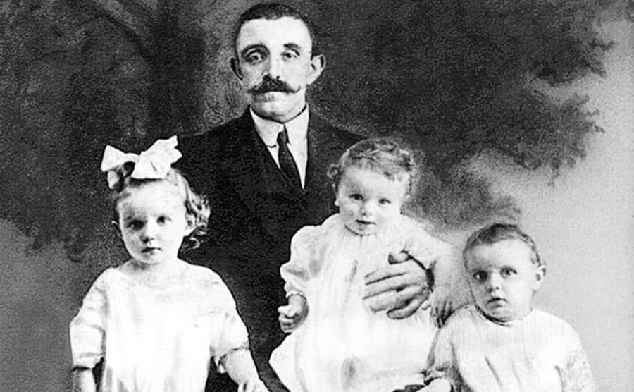 John Collins posing with his children around him 