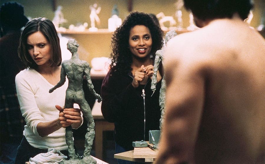 Lisa Nicole Carson with Calista Flockhart sculpting a man posing in front of them in a scene from Ally McBeal 