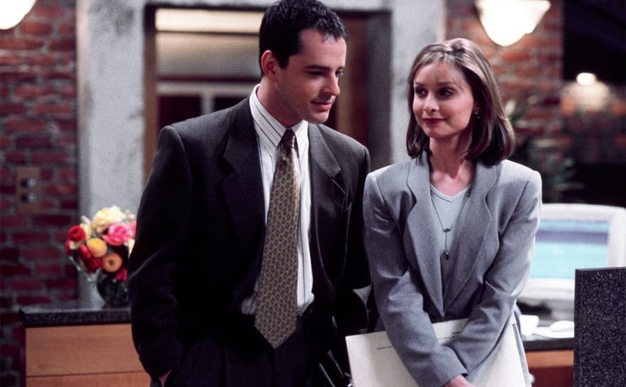 Gil Bellows and Calista Flockhart standing together in an office in a scene from Ally McBeal 
