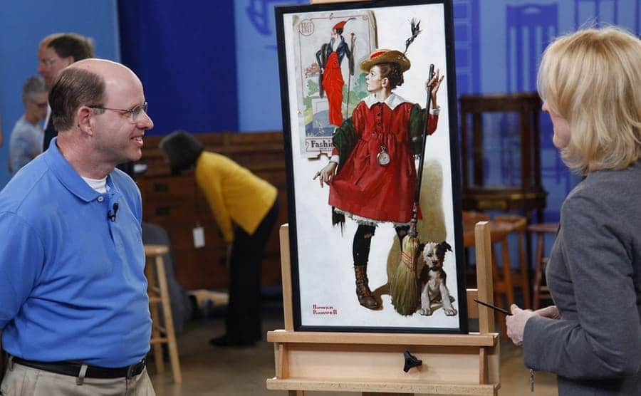 A man and an appraiser admiring an old painting 