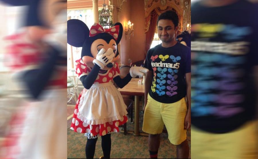 Minnie Mouse covering her eyes and pointing to a man's shirt that says deadmau5