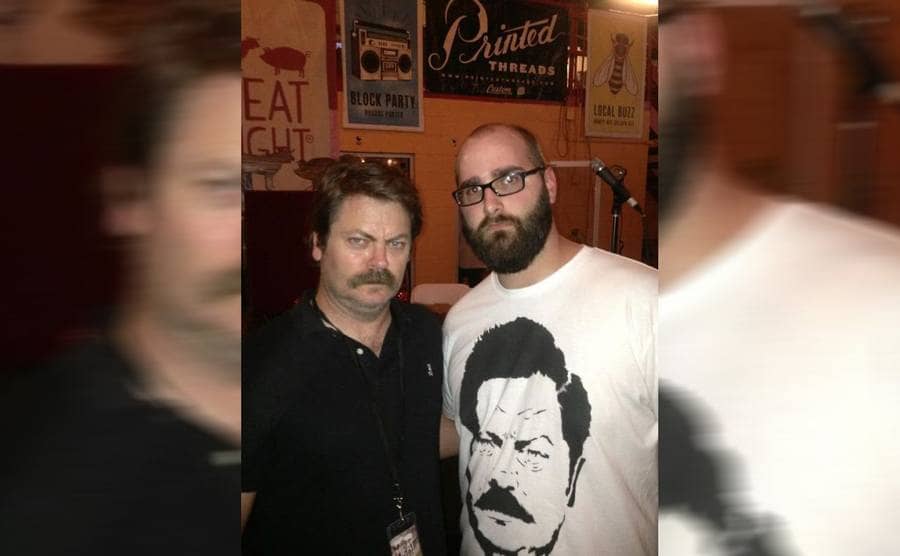 Nick Offerman posing next to a guy wearing a shirt with Ron Swanson on it 