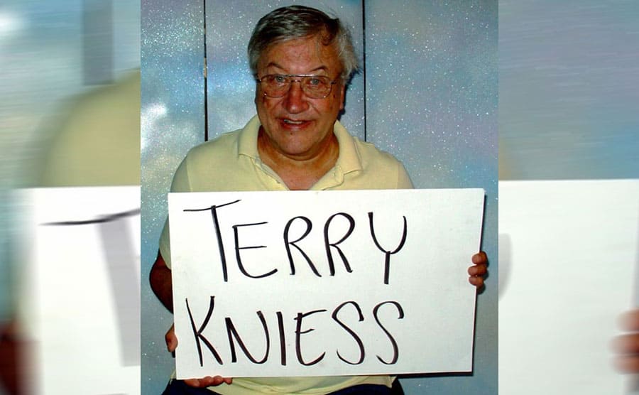 Terry Kniess holding a sign with his name 