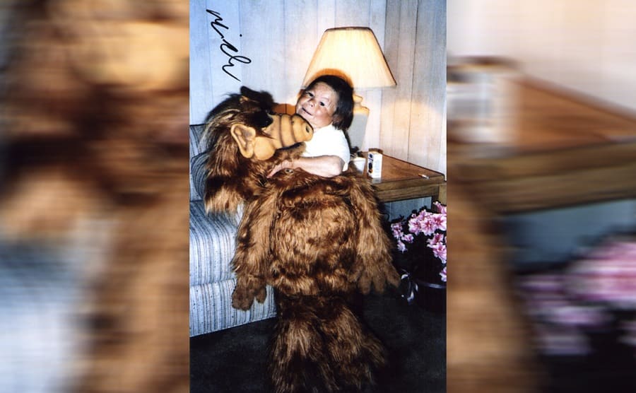 Mihaly Meszaros sitting on the couch posing with the ALF costume 