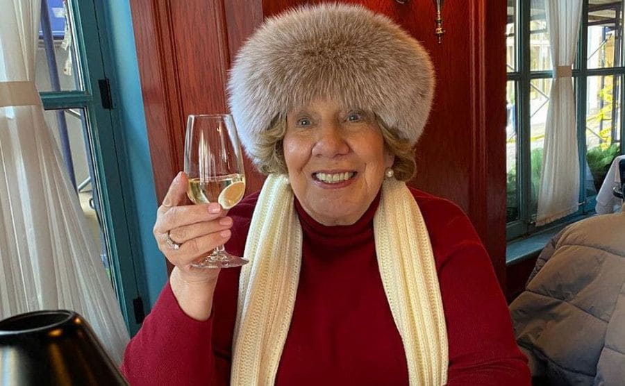 Faye Chrisley wearing a fur hat and toasting