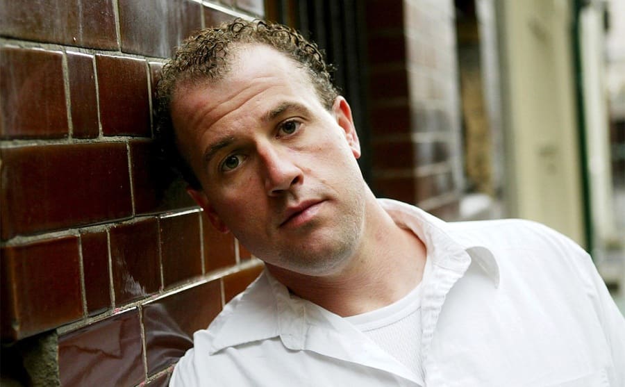 James Frey leaning against a brick wall 